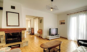 A living room with a fireplace, television, and a dining table. - A Traversa - PRUNELLI DI FIUMORBO (PRUNELLI DI FIUMORBO)