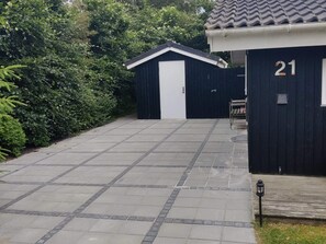 A paved driveway leading to a building with a number 21 sign, surrounded by greenery. - 4 Star Holiday Home in Hemmet (Hemmet)