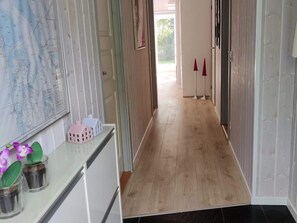 Ein Flur mit Holzboden, einer Karte an der Wand und einem kleinen Hausmodell auf einer Theke.