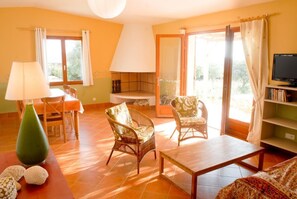 A living room with a sofa, two wicker chairs, a coffee table, a lamp, a TV, and a bookshelf. - Rosemary - MONACIA D'AULLENE (MONACIA D'AULLENE)