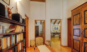 Un pasillo con estanterías de madera, un escritorio y una silla.