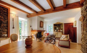 Una habitación acogedora con una mesa de madera, chimenea y pared de piedra.