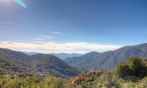 Eine gebirgige Landschaft mit einem Dorf, eingebettet im Tal.