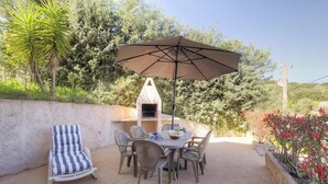 An outdoor patio with a grill, a striped chair, and a table with chairs. - Francesca - SOTTA - Gîte (SOTTA)