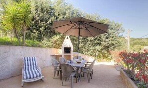 An outdoor patio with a grill, a striped chair, and a table with chairs. - Francesca - SOTTA - Gîte (SOTTA)