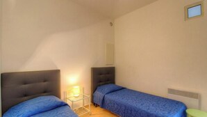 A small, single-room accommodation with two beds, a nightstand, a lamp, and a small window. - Francesca - SOTTA - Gîte (SOTTA)