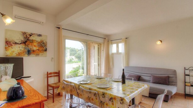 A dining area with a table set for four, a sofa, a TV, and a painting on the wall. - Francesca - SOTTA - Gîte (SOTTA)