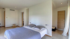 Ein Schlafzimmer mit einem Bett, einem Hocker und einem Kleiderschrank.