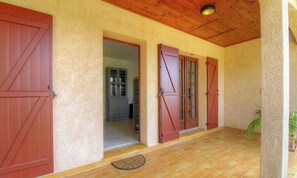 A covered porch with wooden doors and a tiled floor. - L'alivetu - PERI - Gîte (PERI)