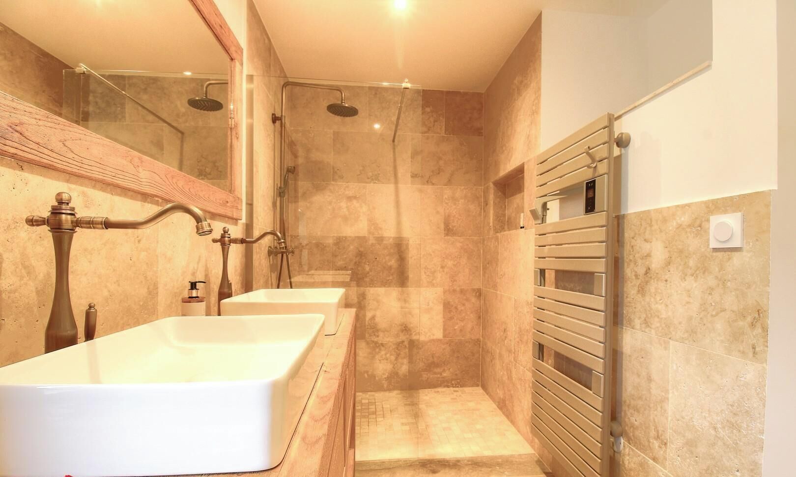 A modern bathroom with a large bathtub, a walk-in shower, and a towel rack.