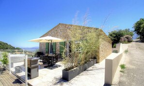A stone building with a patio, outdoor furniture, and a view of the sea. - A Fabrica - CATERI - Guest house (CATERI)