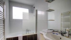 A bathroom with a window, a bathtub, a sink, and a mirror. - Sagone - N°19 - GHISONACCIA (GHISONACCIA)
