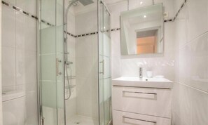 A modern bathroom with a glass-enclosed shower, a white vanity with a mirror, and a tiled floor. - CAPANELLA - SERRA DI FERRO (SERRA DI FERRO)