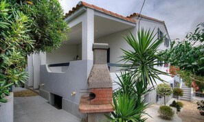 A house with a stone-built barbecue area, a covered porch, and a garden with various plants. - CAPANELLA - SERRA DI FERRO (SERRA DI FERRO)