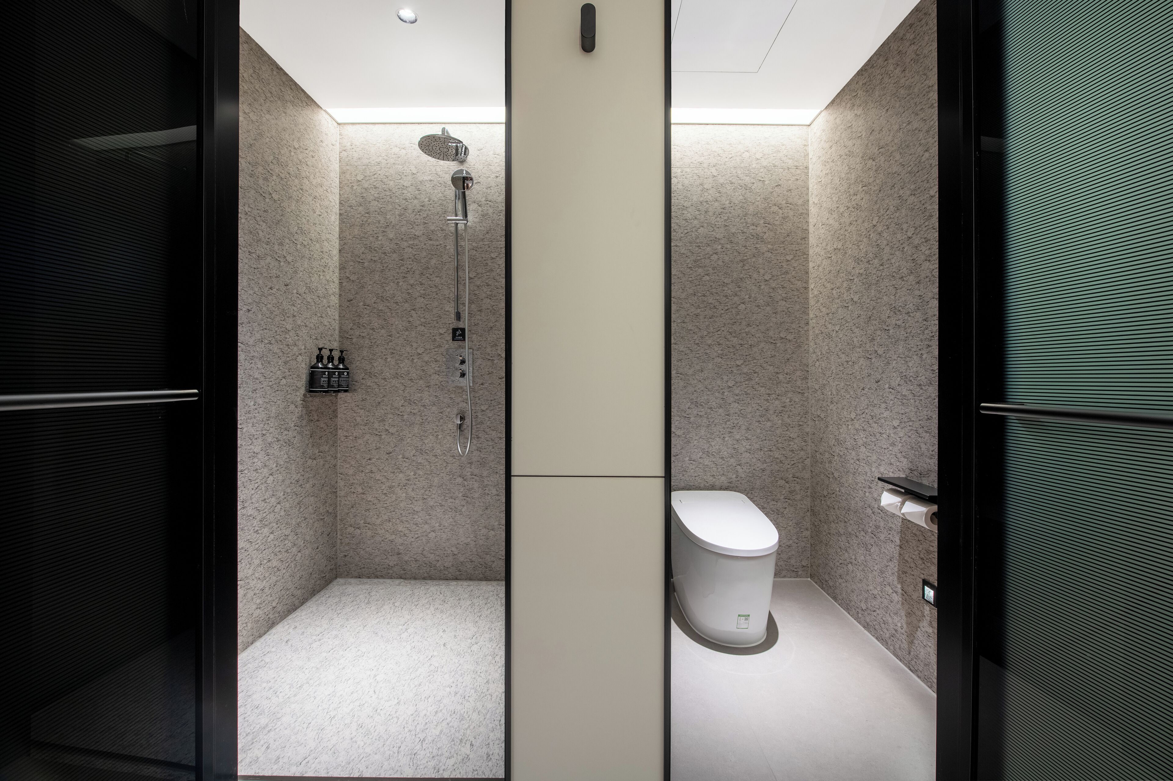 Un baño moderno con ducha, inodoro y armario de almacenamiento.