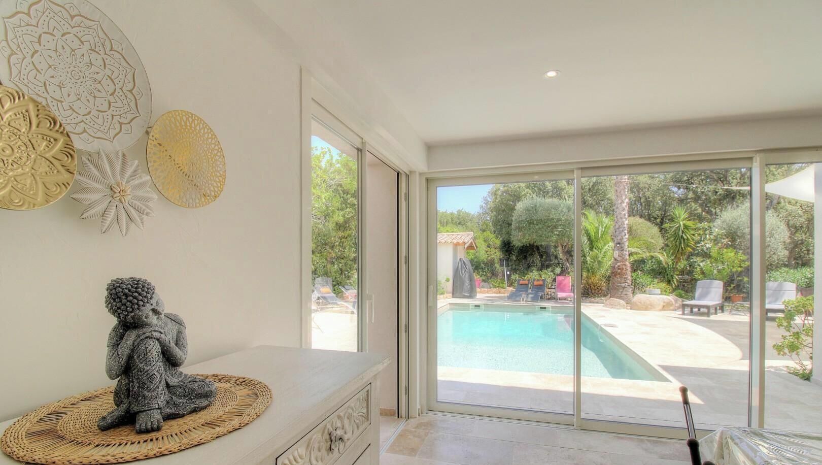 A modern interior with a large sliding glass door leading to an outdoor pool area.