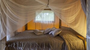 Una cama con dosel, cabecero de madera y almohadas.