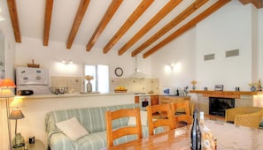 A kitchen with wooden beams, a dining area with chairs, a sofa, and a fireplace. - Piatonu - SOLLACARO - Gîte (SOLLACARO)