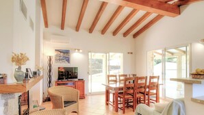 A spacious living area with a wooden ceiling, a dining table with chairs, a television, and a fireplace. - Piatonu - SOLLACARO - Gîte (SOLLACARO)