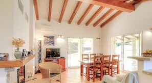 A spacious living area with a wooden ceiling, a dining table with chairs, a television, and a fireplace. - Piatonu - SOLLACARO - Gîte (SOLLACARO)