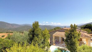 A house with a tiled roof, a patio with a chair, and a view of mountains. - Piatonu - SOLLACARO - Gîte (SOLLACARO)