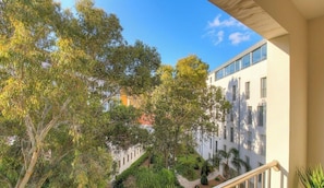 A balcony with a view of a building, trees, and a clear sky. - L'albert 1er - AJACCIO (AJACCIO)