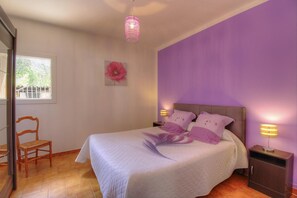 A bedroom with a bed, a chair, a nightstand, a lamp, and a window. - Villa Monlabeur 2 - AJACCIO (AJACCIO)