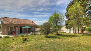 A stone house with a tiled roof, a covered patio with chairs, and a small garden with trees and grass. - Tarri-Vecchi - PORTO VECCHIO (PORTO VECCHIO)