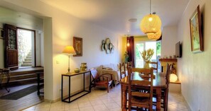 A dining area with a table and chairs, a lamp, a sofa, and a staircase leading to another room. - Cardu - MURACCIOLE - Gîte (MURACCIOLE)