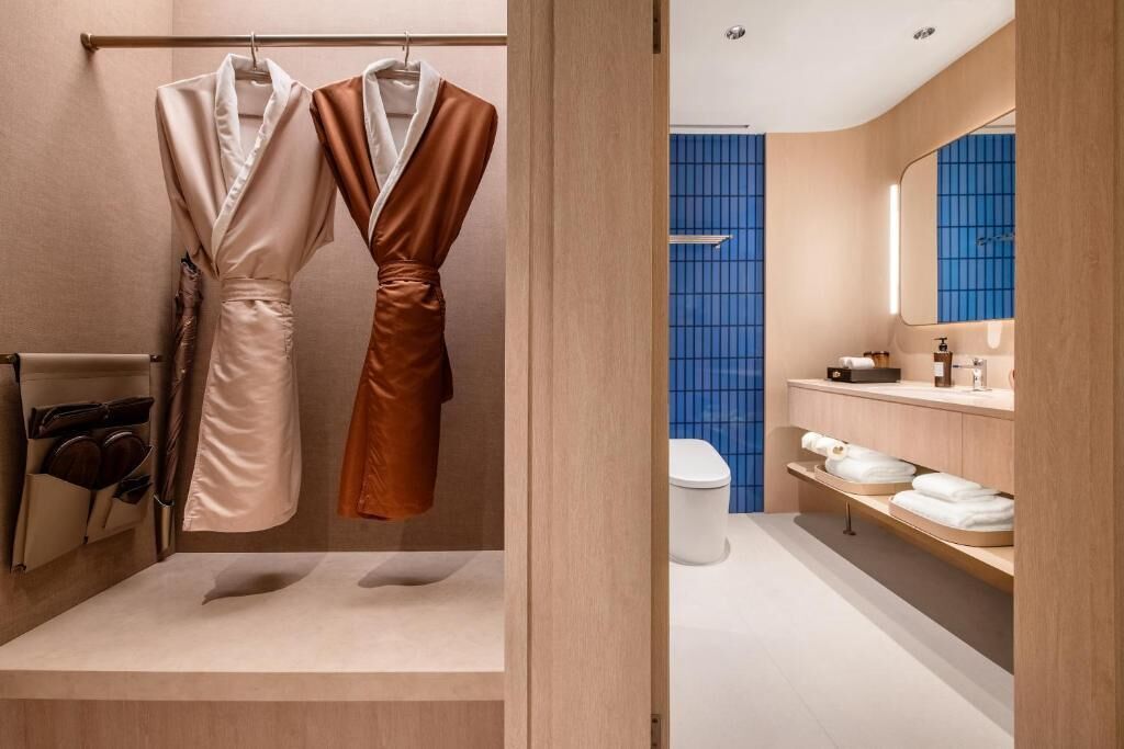 A modern bathroom with a bathtub, a toilet, and a vanity with a mirror.