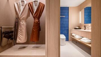 A modern bathroom with a bathtub, a toilet, and a vanity with a mirror.