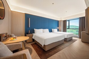 A hotel room with two beds, a dining table, a small kitchen area, and a large window with a view. - Crystal Hotel Weihai Happiness Gate (Weihai)