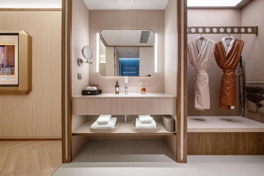 Un baño moderno con tocador de madera, un espejo, un lavabo y dos toallas.