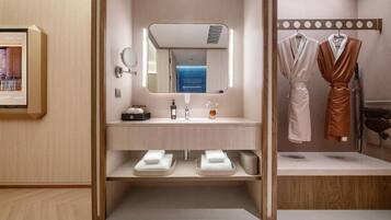Un baño moderno con tocador de madera, un espejo, un lavabo y dos toallas.
