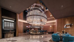 A modern lobby with a central bar area, seating arrangements, and a distinctive ceiling design. - Crystal Hotel Weihai Happiness Gate (Weihai)
