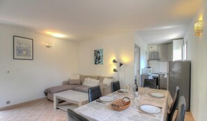 A compact living space with a dining area, kitchenette, and a sofa. - Tivarellu - FIGARI - Gîte (FIGARI)