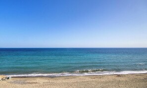 Ein Strand mit klarem, blauem Wasser und einem Sandufer.