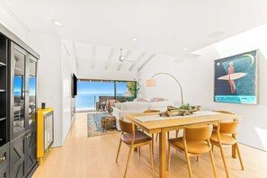 A modern interior with a dining area, kitchen, and a large window overlooking the ocean. - Oceanfront Solana Beach 2 BDR Condo (Solana Beach)