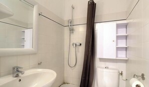 Ein Badezimmer mit Waschbecken, Toilette, Dusche und Spiegel.