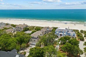 Una zona residencial costera con casas, una playa y una vista despejada del océano.
