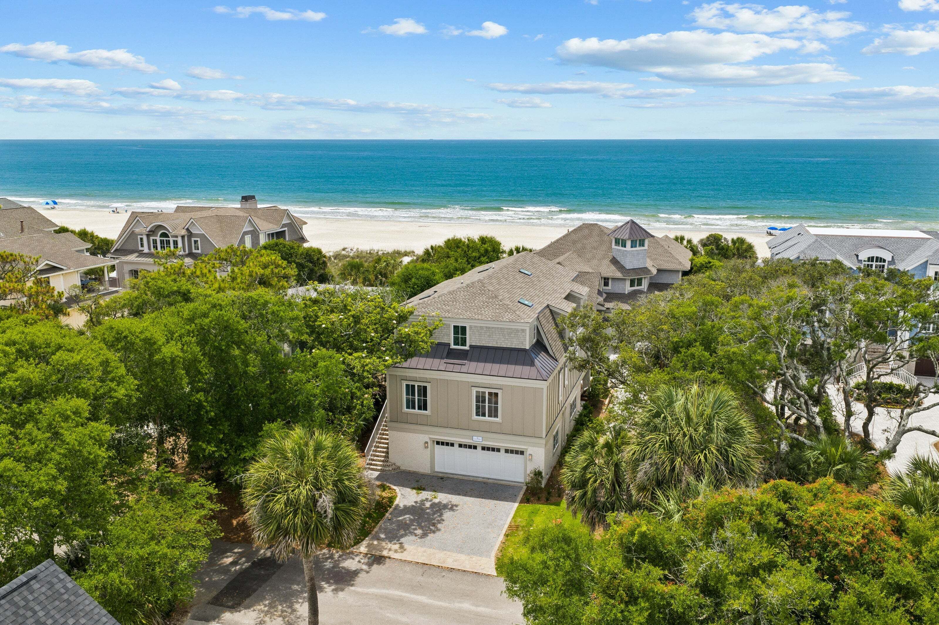 A residential area with houses, a beach, and a clear sky.