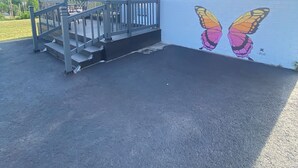 A building with a white brick exterior, a wooden staircase leading to a porch, and a mural of butterflies on the side. - Tranquil 3 bedroom 2bath Home with AC in Hendersonville 15mins from Nashville TN (Hendersonville)