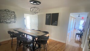 A dining area with a large table and chairs, a ceiling light fixture, and wall decorations. - Tranquil 3 bedroom 2bath Home with AC in Hendersonville 15mins from Nashville TN (Hendersonville)