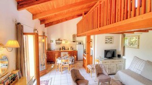 A cozy living area with a dining table, chairs, a sofa, a television, and a kitchen in the background. - ORTIGLIESI - SERRA DI FERRO (SERRA DI FERRO)