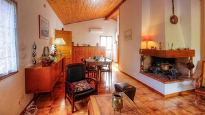 Ein gemütliches Wohnzimmer mit Kamin, Holzmöbeln und einem Essbereich.