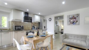 Una cocina moderna con comedor, un sofá y un reloj en la pared.