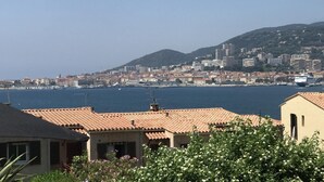 A coastal cityscape with buildings, a clear sky, and a body of water. - AICCU BELLU - AJACCIO (AJACCIO)