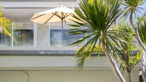 Ein modernes Haus mit Pool, Essbereich und einer Lounge mit Sessel und Tisch.