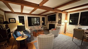 Una sala de estar con chimenea, televisor y sofá.