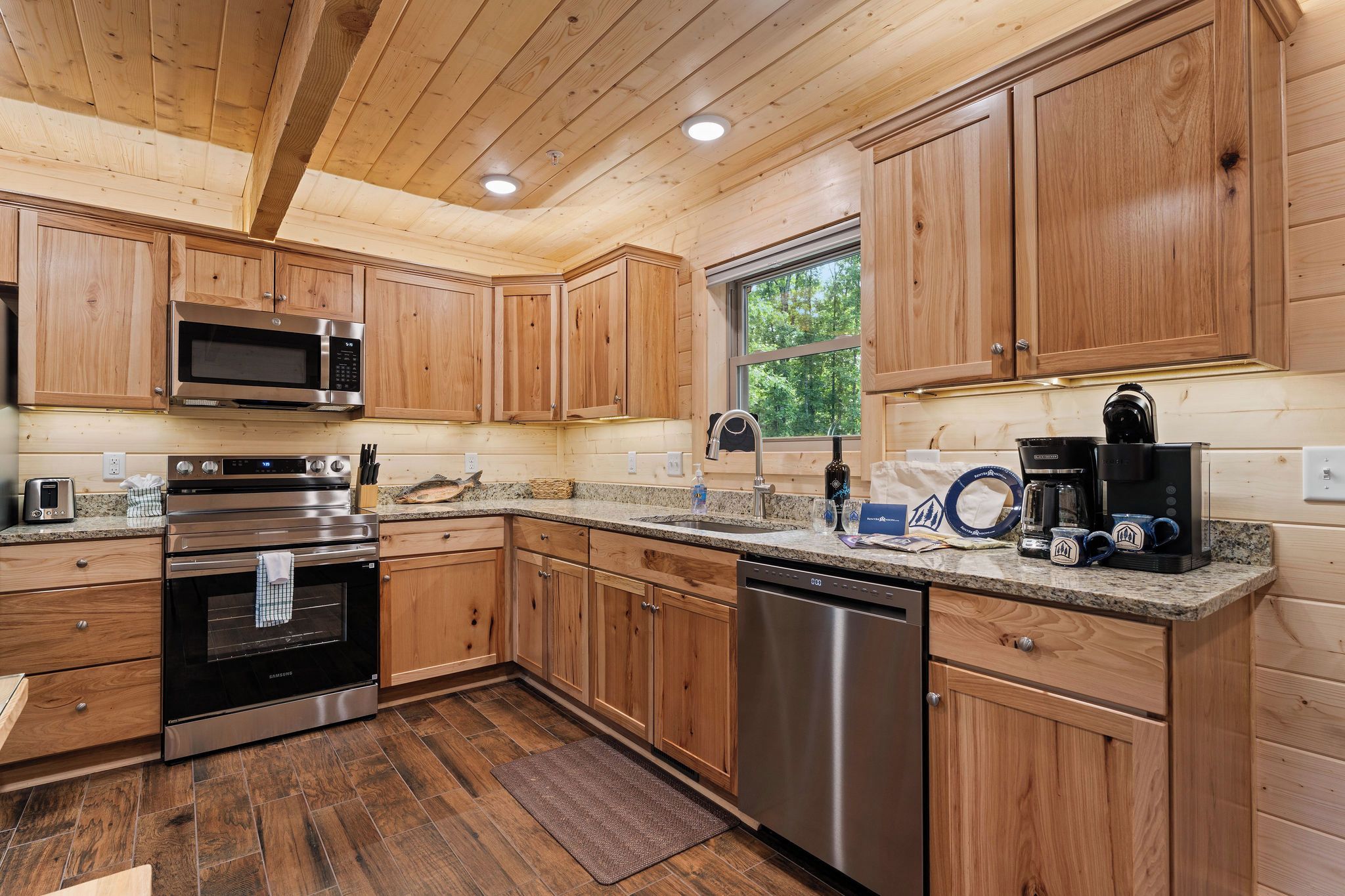 Una cocina moderna con armarios de madera, electrodomésticos de acero inoxidable y encimera de granito.